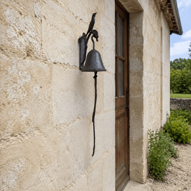 Small cast-iron bird doorbell on a stone façade