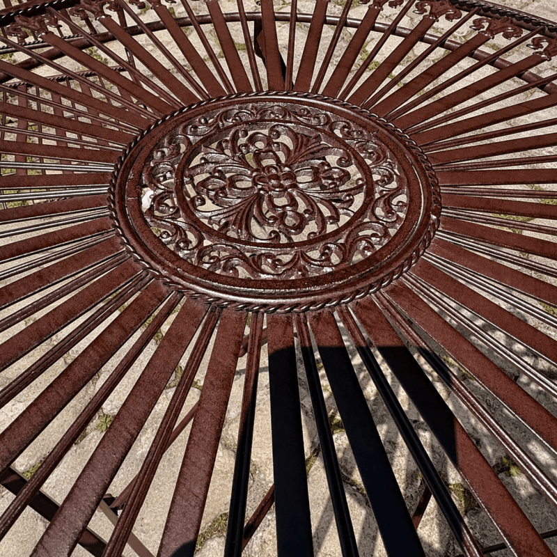 Decorative radial tabletop of aged brown garden bistro set