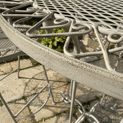 Decorative floral details on aged cream-white metal bistro set