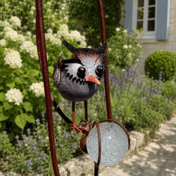 Baby owl and amber glass counterweight on garden mobile