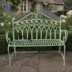 Green metal garden bench with a backrest decorated with flowers