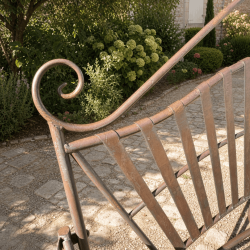 Detail of the arabesques and backrest of the wrought-iron garden bench