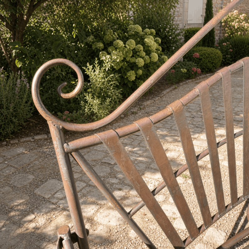 Detail of the arabesques and backrest of the wrought-iron garden bench