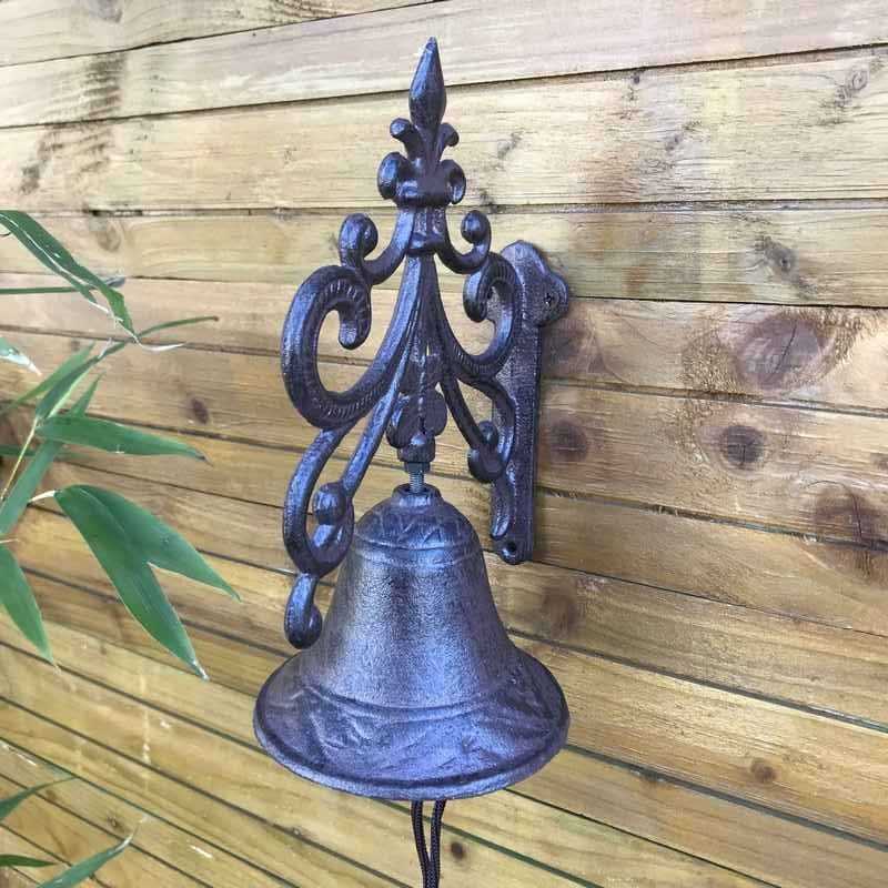 Side view of cast iron garden gate doorbell with arabesque and fleur-de-lys design