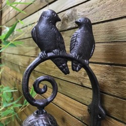 Close-up view of cast iron bird couple bell