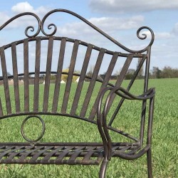 Close-up view of an arabesque wrought-iron garden bench
