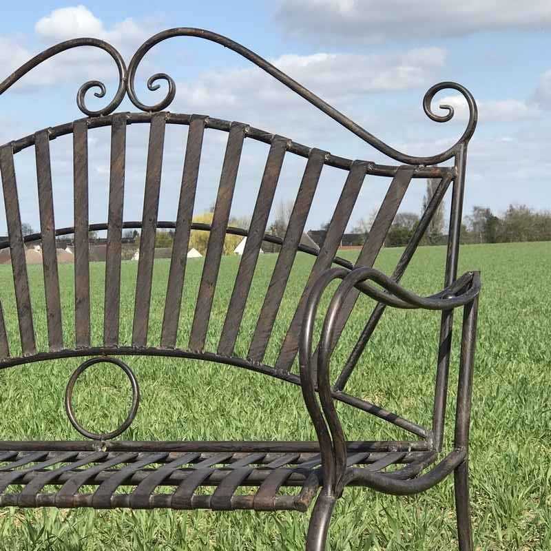 Close-up view of an arabesque wrought-iron garden bench