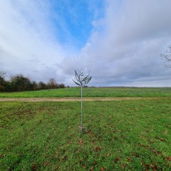 Decorative garden wind spinner in gray iron, Gonfreville windmill style, viewed from a distance