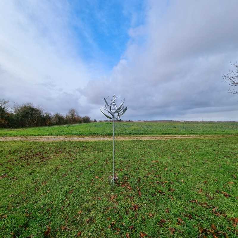 Decorative garden wind spinner in gray iron, Gonfreville windmill style, viewed from a distance