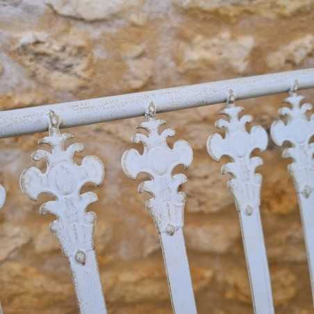 Antique-white backrest of the wrought-iron garden bench