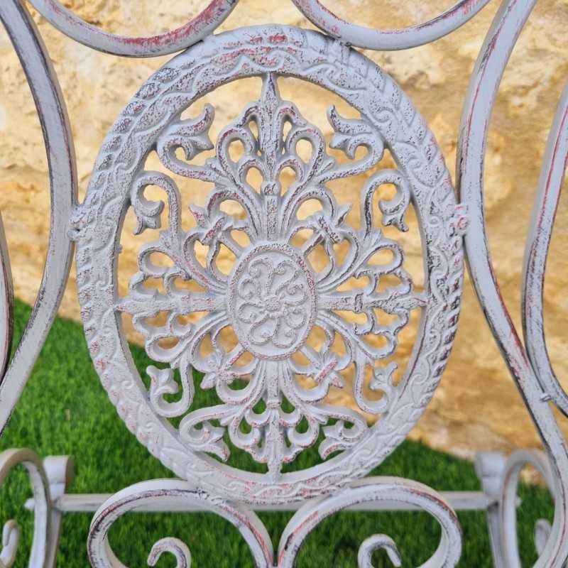 Rocking chair Iron and cast-iron rocking chair with a weathered gray patina, outdoor view of the cast-iron piece