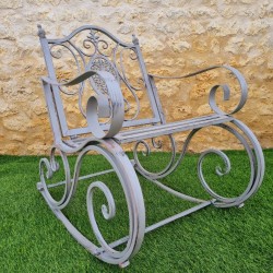 Rocking chair, iron and cast iron armchair with an aged gray patina, outdoor, side view
