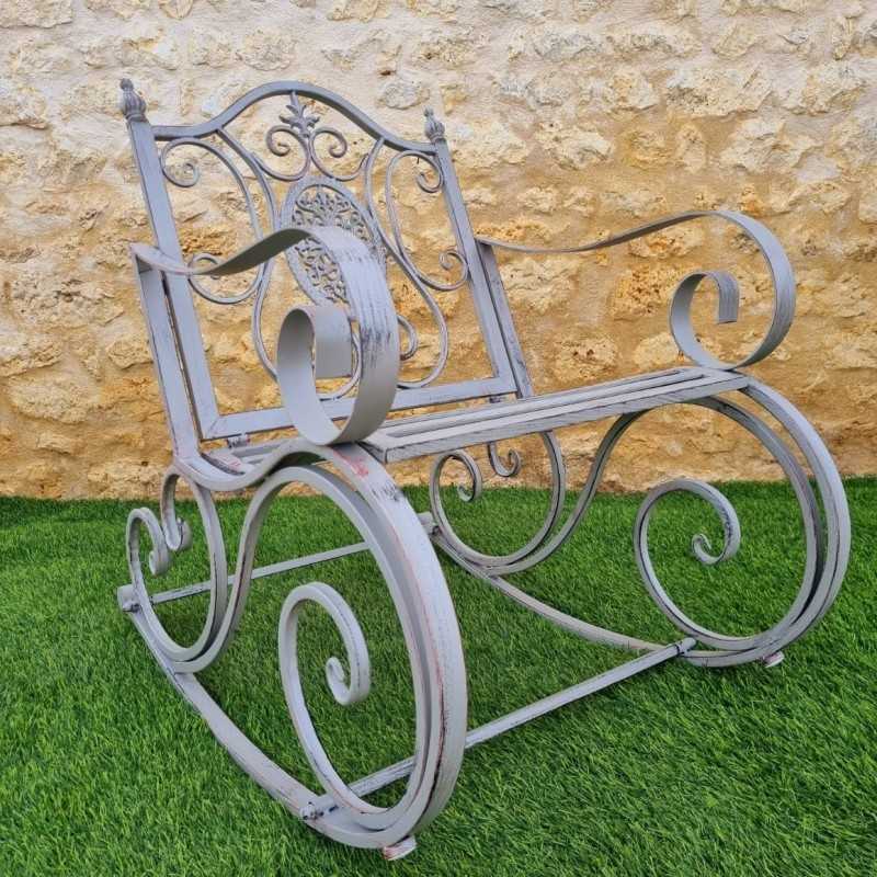 Rocking chair, iron and cast iron armchair with an aged gray patina, outdoor, side view