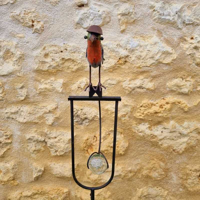 Counterbalance, metal stake, and glass bird with hat