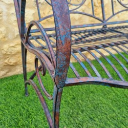 Antique rust-patina wrought-iron garden bench, comfortable, armrest view