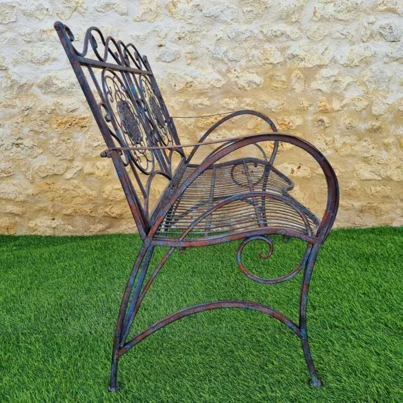 Comfortable antique rust-patina wrought iron garden bench, side view
