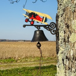 Close-up view of the cast iron bell featuring its vintage airplane design