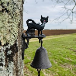 Cast-iron wall bell with black cat – shown in a garden setting