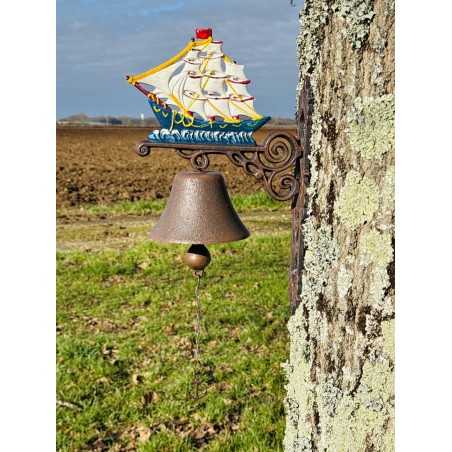 Wall-mounted cast-iron doorbell with a full-view sailboat