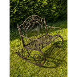Patina-finished brown metal outdoor rocking bench – side view in a garden
