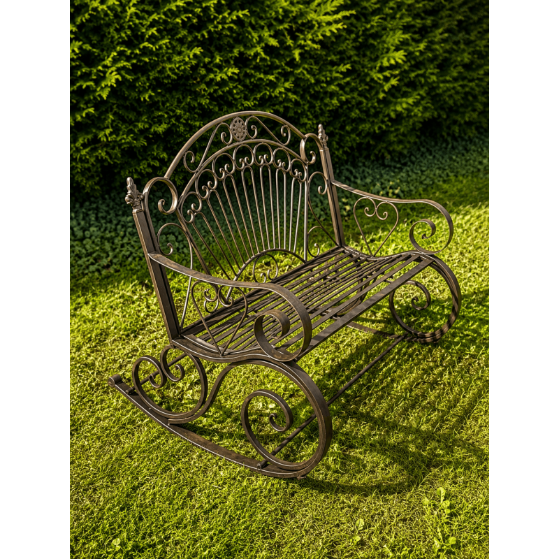 Patina-finished brown metal outdoor rocking bench – side view in a garden