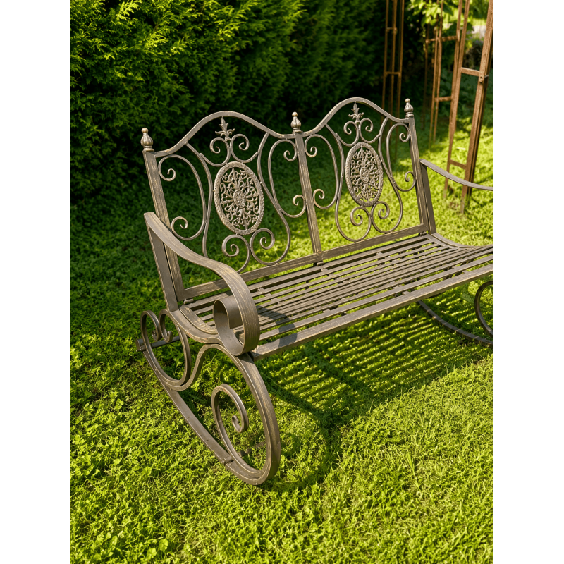 Weathered brown metal garden rocking chair, three-quarter view