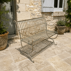 Patinated verdigris-rust metal garden bench on a terrace
