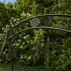Brown two-seater garden swing with fold-down trays