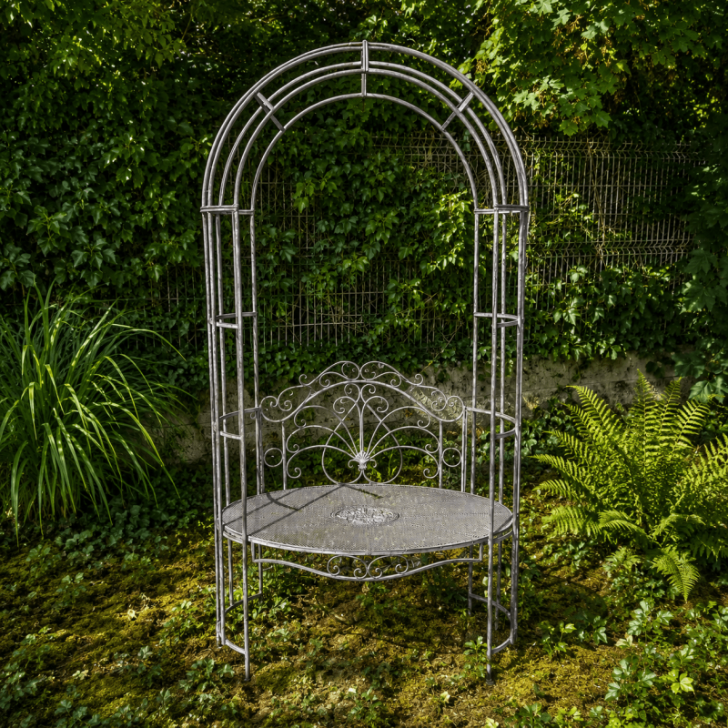 Romantic bench with an arch installed among climbing plants