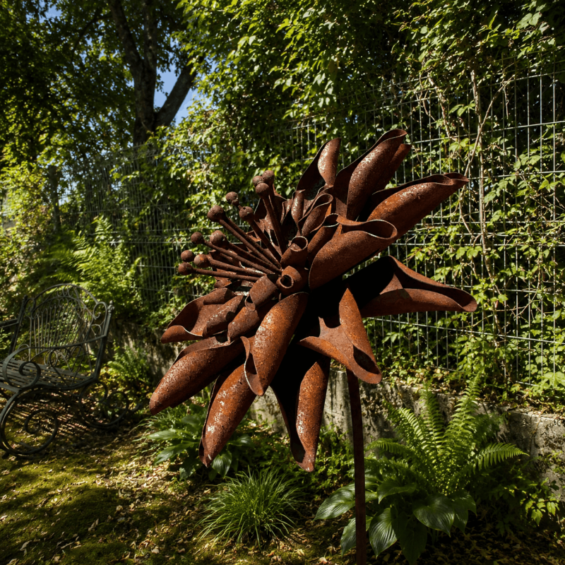 Rust-colored metal dahlia on a stake – side view