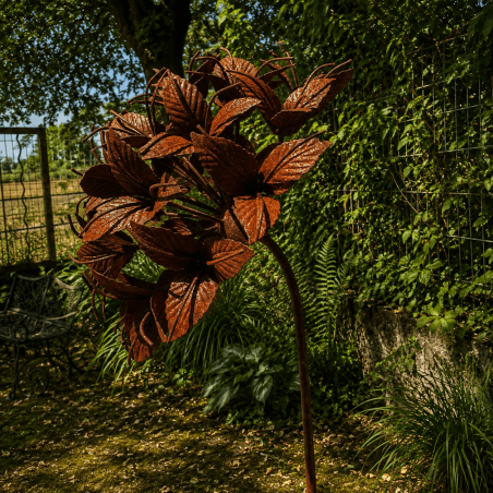 Rust-colored metal flower on a stake – side view