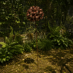 Rust-colored metal flower on a stake – overview