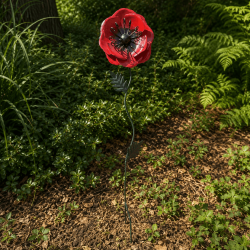 Red metal poppy installed in the garden