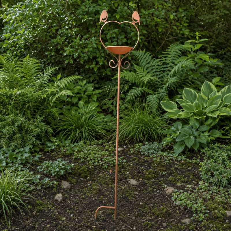 Heart-shaped bird feeder garden stake amongst plants