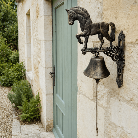 Wall-mounted cast-iron horse doorbell, golden-brown finish, side view